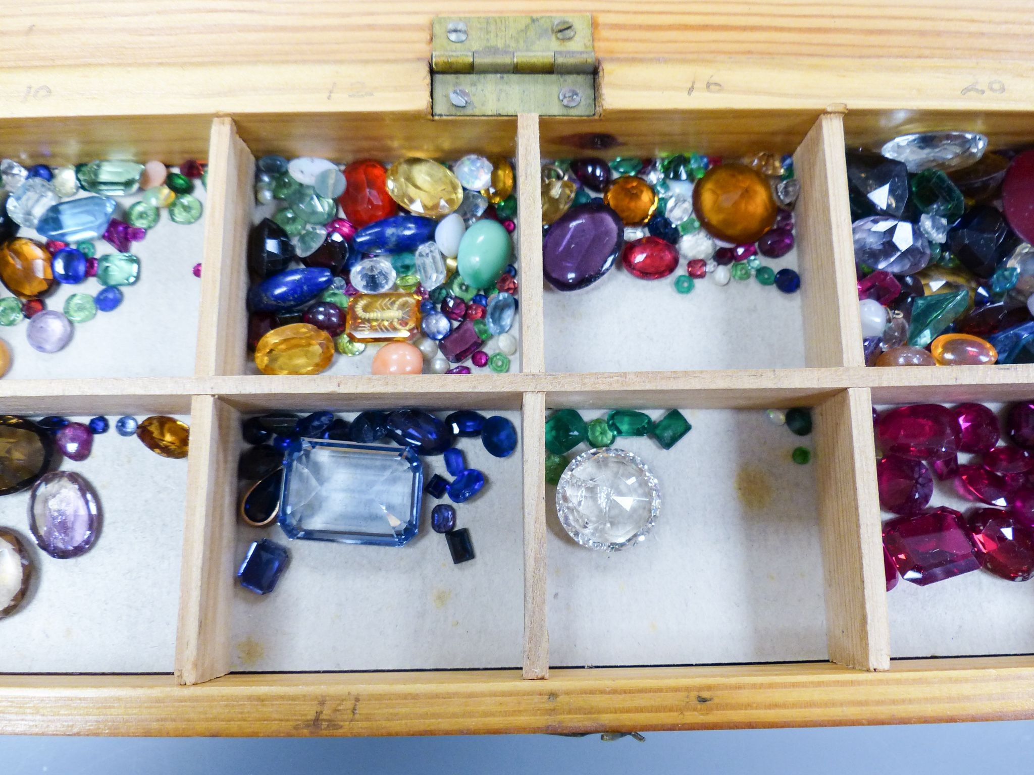 A quantity of unmounted gemstones, housed in a wooden box, including opal, opal doublet, bloodstone, turquoise, amethyst, rock crystal etc.